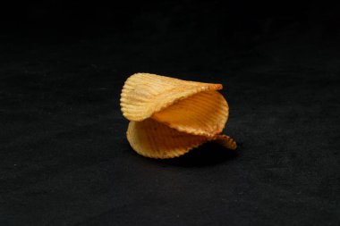 Siyah yüzeyde lezzetli patates cipslerine yakın çekim