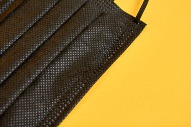 Sarı arka planda siyah tıbbi maskelerin yakın plan görüntüsü 