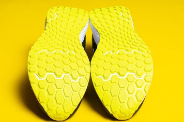 Sarı arka planda şık spor ayakkabıların yakın plan görüntüsü 