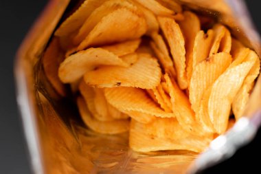 Paketteki lezzetli patates cipsinin yakın plan görüntüsü.