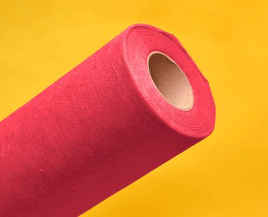 Sarı arkaplanda pembe kağıt rulosu