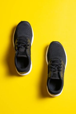 Sarı arka planda şık siyah spor ayakkabılarının yakın plan görüntüsü 