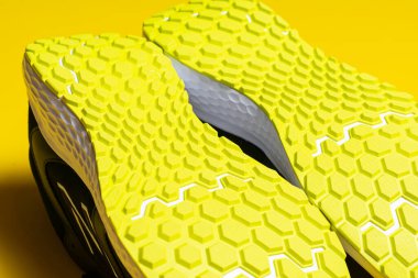 Sarı arka planda şık spor ayakkabıların yakın plan görüntüsü 