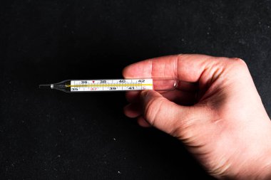 Siyah arkaplanda insan eli termometresi