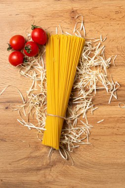 Ahşap arka planda domatesli pişmemiş spagetti manzarası.