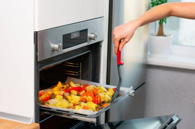 Kırpılmış kadın fırında lezzetli yemekler pişiriyor.