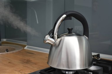 Mutfaktaki ocakta kaynayan su ısıtıcısının yakın çekim görüntüsü.