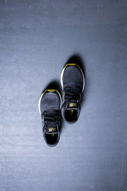 Siyah arkaplanda fotokopi alanı olan şık siyah spor ayakkabılarının yakın plan görüntüsü