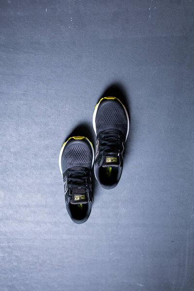 Крупный план стильных черных кроссовок на черном фоне с копировальным пространством
