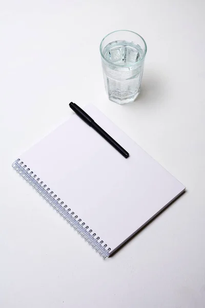 Caderno Com Caneta Copo Água Fundo Branco — Fotografia de Stock