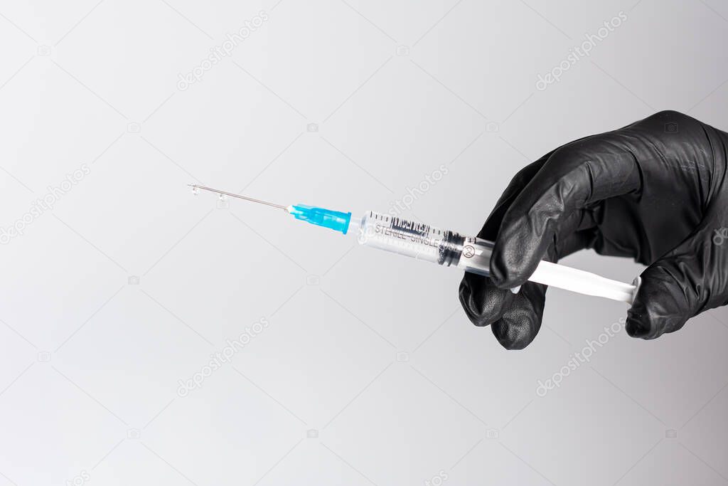 hand holding syringe with a medical vaccine