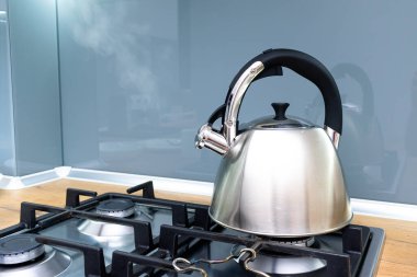 Mutfaktaki ocakta kaynayan su ısıtıcısının yakın çekim görüntüsü.