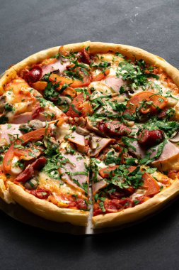 Jambon, peynir ve mantarlı lezzetli pizzanın yakın plan görüntüsü. 