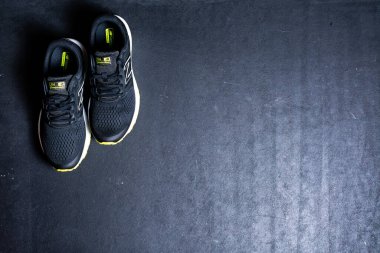 Siyah arkaplanda fotokopi alanı olan şık siyah spor ayakkabılarının yakın plan görüntüsü