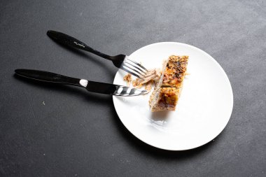 Yakın plan lezzetli ızgara et, çatal ve bıçak tabakta.