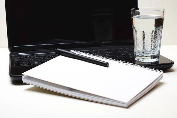 Φορητό Υπολογιστή Σημειωματάριο Στυλό Και Ποτήρι Νερό Λευκό Τραπέζι — Φωτογραφία Αρχείου