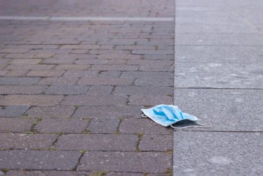 Cerrahi maske yerde yatıyor ve onu kirletiyor. seçici odak