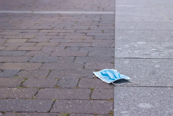 Cerrahi maske yerde yatıyor ve onu kirletiyor. seçici odak