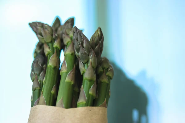 Asparagus. Fresh green asparagus on a light blue clear background. — Stock Photo, Image