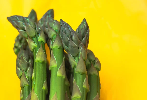 Asparagus. Fresh green asparagus on a bright yellow clear background. — Stock Photo, Image