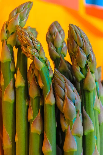 Asparagus. Fresh green asparagus on a bright yellow clear background. — Stock Photo, Image