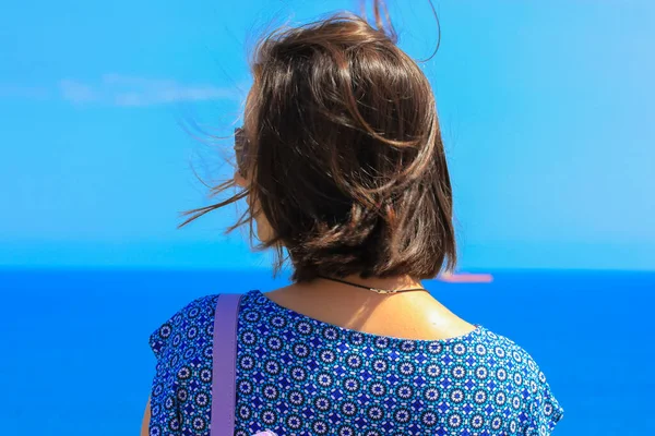 Bella ragazza con i capelli corti scuri in piedi vicino al mare e guardando altrove. — Foto Stock