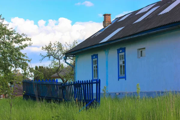 春天或夏天的典型乌克兰风景 白色粘土小屋和蓝色木制围栏 — 图库照片