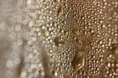 İçki damlaları - bira, kahve ya da siyah çay - bardaktan aşağı yakın çekim.