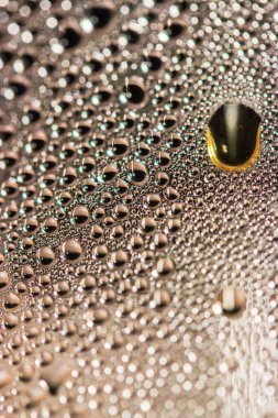 İçki damlaları - bira, kahve ya da siyah çay - bardaktan aşağı yakın çekim.