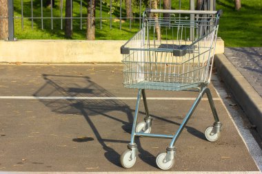 Güneşli bir günde süpermarkette boş metal araba.