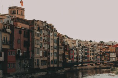 Girona, İspanya 1 Haziran 2024 nehir kenarındaki renkli binalar Girona 'daki tarihi mimarinin manzarası nehir boyunca uzanan renkli binalar, berrak bir gökyüzü altında pitoresk bir şehir manzarası yaratıyor.