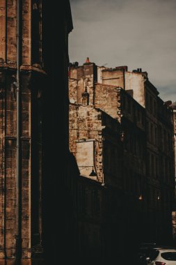 Bordeaux, Fransa 'da zarif bir Avrupa mimarisi. Avrupa 'da bulutlu bir günde eski binalar. Taş ve tuğla cepheleri ve bulutlu gökyüzü karışımı eski binaların kasvetli bir görüntüsü..