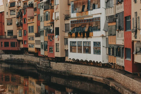 Girona, İspanya 1 Haziran 2024 nehir kenarındaki renkli binalar Girona 'daki tarihi mimarinin manzarası nehir boyunca uzanan renkli binalar, berrak bir gökyüzü altında pitoresk bir şehir manzarası yaratıyor.