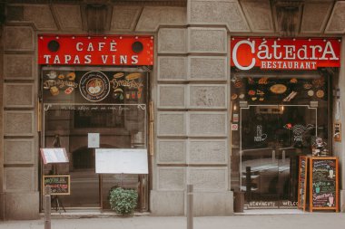 Barselona, İspanya 2 Mayıs 2024 Bir davet sokak sahnesi Bir kafe veya restoran ön cephelerini gösteren Hoş geldiniz işaretleri ve kırmızı mağazalar. Şehir manzarası. İspanyol sokağı. Tapas, asma barı tabelası