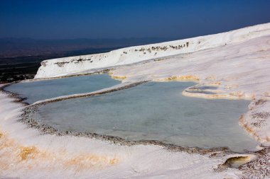 Maden suyu havuzlu doğal travertin teraslar. Benzersiz kireçtaşı oluşumları, beyaz kayalar ve turkuaz temiz su. Seyahat, doğa, jeoloji ve egzotik manzara kavramları için mükemmel..
