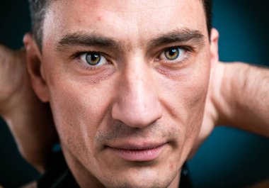 Stüdyoda genç beyaz adamın portresini kapat. Kameraya bak, iyimser ol.