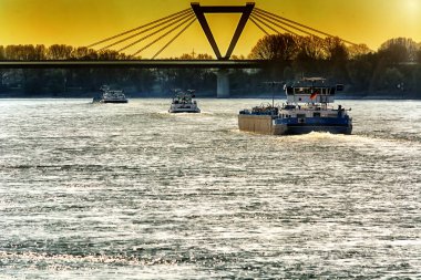 Almanya Dusseldorf yakınındaki Ren Nehri yataydan. Ters banka ve dramatik gökyüzü Hava Meydanı köprü görünümü.
