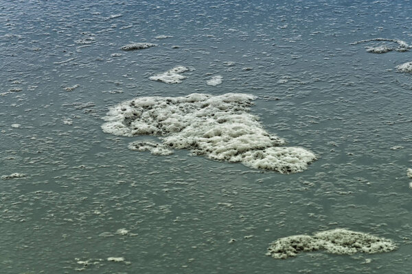 Dirty water with foam on the water surface