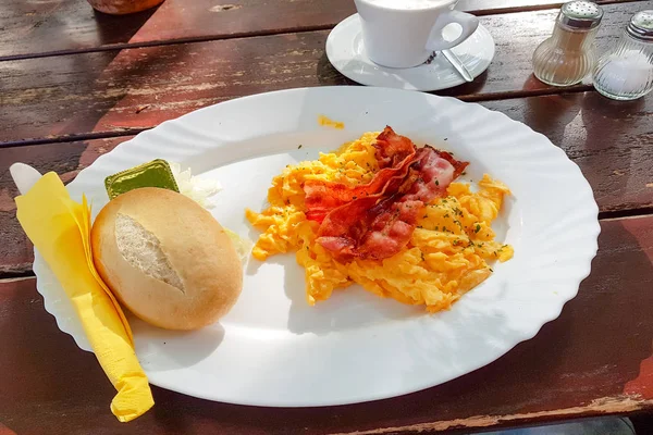 Bir tabakta çırpılmış yumurta. Yağda yumurta, tost, meyve suyu ve kahveyle güzel bir kahvaltı.