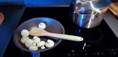 Kaynar erişteli gümüş bir tencere ve siyah seramik bir tavada dökme demir bir tava.