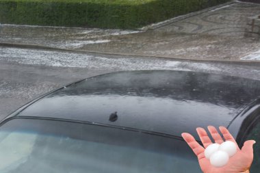 Dolu fırtınasından sonra arabanın kaputunda büyük dolu topları var.