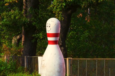 Yeşil arka planda beyaz ve kırmızı çizgili bowling konisi
