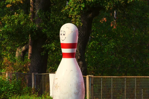 Yeşil arka planda beyaz ve kırmızı çizgili bowling konisi