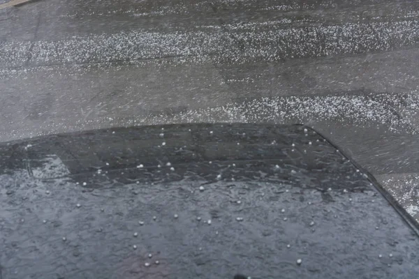 Dolu fırtınasından sonra arabanın kaputunda büyük dolu topları var.