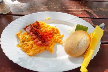 Bir tabakta çırpılmış yumurta. Yağda yumurta, tost, meyve suyu ve kahveyle güzel bir kahvaltı.