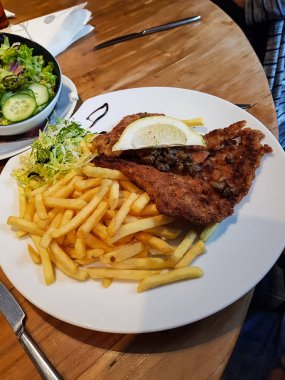 Patates kızartması ile servis edilen tavuk içindeki şinitzel