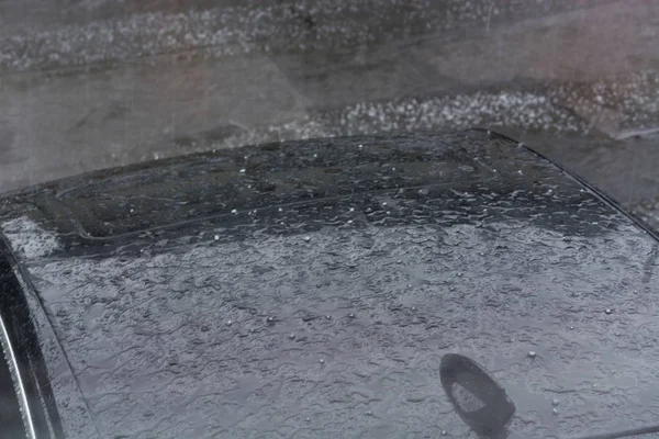 Granizo cai em um telhado de carro preto . — Fotografia de Stock