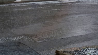 Dolu fırtınasından sonra arabanın kaputunda büyük dolu topları var.