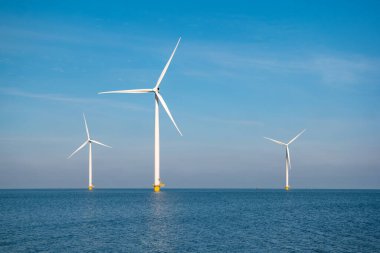 Yel değirmeni parkı Batı Hollanda, rüzgâr değirmeni türbini okyanusta mavi gökyüzü, yeşil enerji
