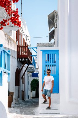 Yunan adası Mykonos 'ta tatilde olan genç adam, Mykonos Adası' ndaki küçük Venedik köyünde dinlenen adamlar.